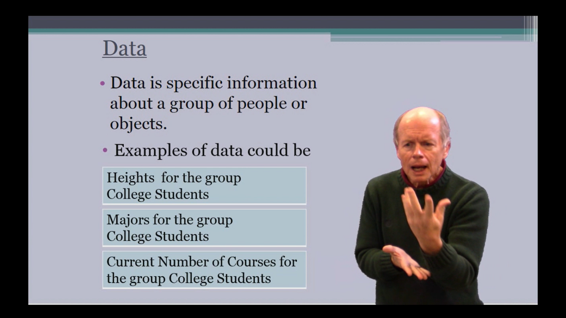 A photograph of a presentation with a slide about data and a sign language interpreter in front